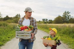 Een man en zijn zoontje met natuurlijk 'voedsel van de boer' Een man en zijn zoontje met natuurlijk 'voedsel van de boer'
