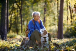 Vrouw ontspant met haar hond in een bos Vrouw ontspant met haar hond in een bos