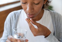 Vrouw neemt vitamine D3 in Vrouw neemt vitamine D3 in