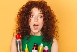 Roodharige dame met haarverzorgingsproducten Roodharige dame met haarverzorgingsproducten