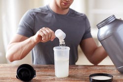 Man maakt een shake met eiwitpoeder Man maakt een shake met eiwitpoeder