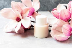 Magnoliabloemen met cosmeticaflesje erbij