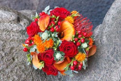 Rood-oranje boeket met daarin ook saffloerbloemen