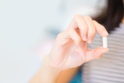 Hand van een vrouw die een lactase supplement vasthoudt Hand van een vrouw die een lactase supplement vasthoudt