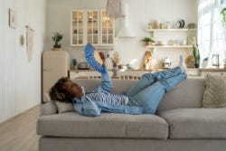 Vrouw ligt op de bank met een waaier Vrouw ligt op de bank met een waaier