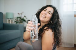 Vrouw met overgewicht met waterflesje Vrouw met overgewicht met waterflesje