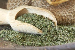 Gedroogde brandnetel en een houten lepel Gedroogde brandnetel en een houten lepel