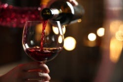 Glas rode wijn wordt ingeschonken Glas rode wijn wordt ingeschonken