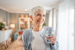 Vrouw met een glas water in haar hand Vrouw met een glas water in haar hand