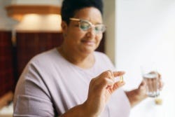 Vrouw neemt visoliesupplement Vrouw neemt visoliesupplement