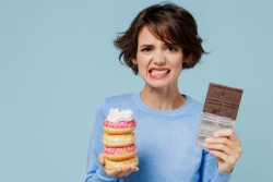 Gestresste vrouw met chocolade en gebak