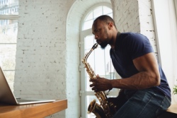 Man blaast op zijn saxofoon