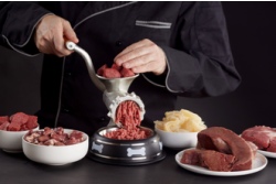 Man met rood vlees om zich heen draait gehakt