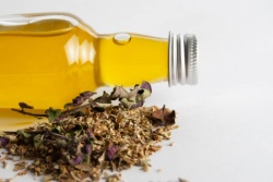 Liggende fles oregano-olie met bosje oregano