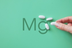 Afbeelding met de letters Mg van magnesium en enkele tabletten