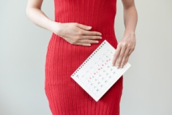 Vrouw met menstruatiepijn houdt haar buik vast