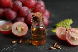 Druivenpitextract in een flesje en losse druiven Druivenpitextract in een flesje en losse druiven