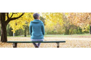 Vrouw op een bankje in een park in de herfst