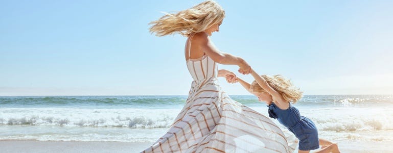 Energieke vrouw met kindje op het strand