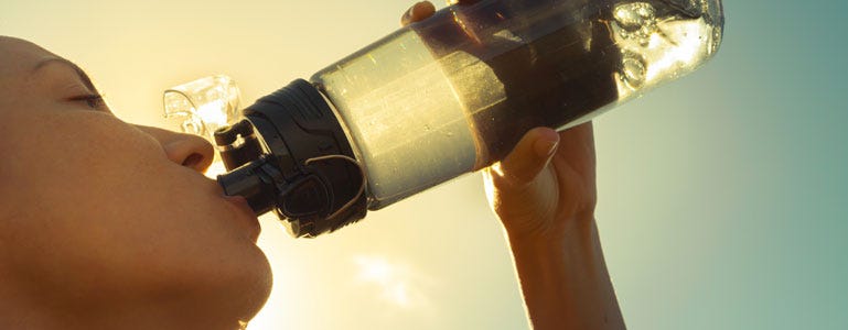 Vrouw drink water uit bidon