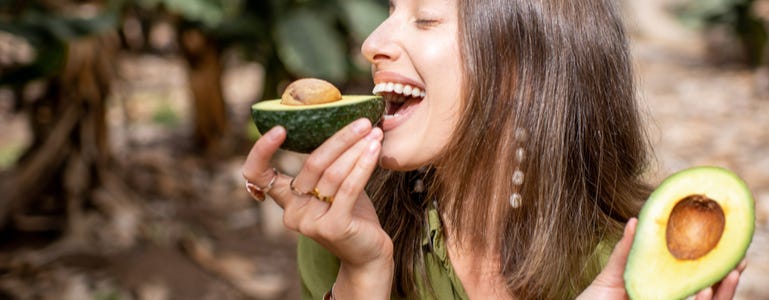 Vrouw eet avocado