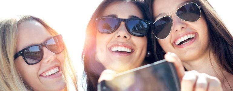 Drie gelukkige jonge vrouwen met een gave huid
