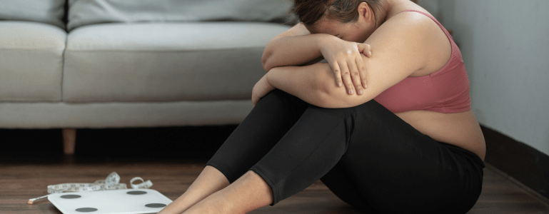 Verdrietige vrouw met gewichtsplateau bij het afvallen