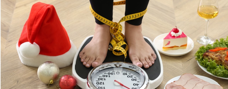 Vrouw op weegschaal na de feestdagen