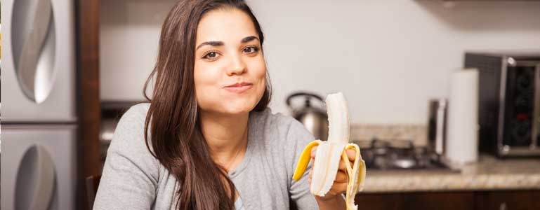 Vrouw eet banaan