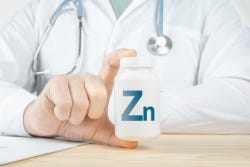 Vrouw houdt afkorting van zink in haar hand