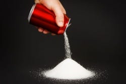 Blikje cola waar suiker uit wordt gegoten Blikje cola waar suiker uit wordt gegoten