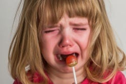 Huilend meisje krijgt een lolly Huilend meisje krijgt een lolly