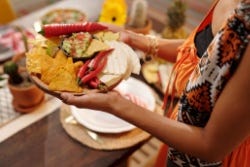Vrouwenarmen met een bord pittig eten Vrouwenarmen met een bord pittig eten