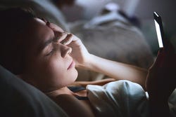Vrouw kijkt in het donker op haar telefoon Vrouw kijkt in het donker op haar telefoon
