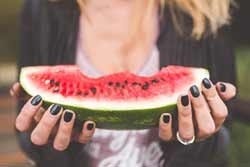 Vrouw eet groot stuk watermeloen Vrouw eet groot stuk watermeloen