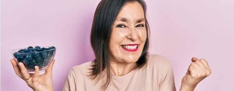 Vitale oudere vrouw met bosbessen