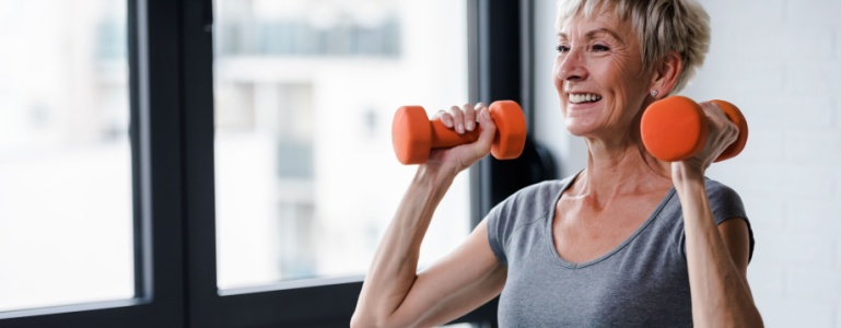 Vrouw van middelbare leeftijd gewichten in de hand