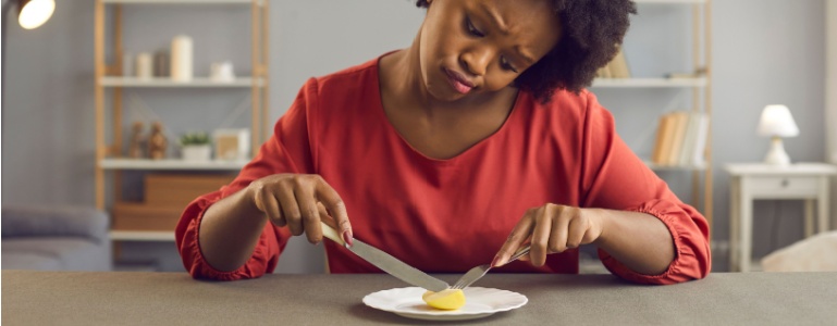 Vrouw eet met moeite een klein stukje voedsel