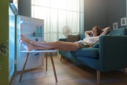 Vrouw ligt met haar voeten in de koelkast Vrouw ligt met haar voeten in de koelkast