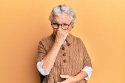 Vrouw ruikt een onprettige geur Vrouw ruikt een onprettige geur