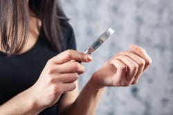 Vrouw bekijkt haar nagels met een vergrootglas Vrouw bekijkt haar nagels met een vergrootglas