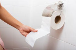 Vrouwenhand pakt een stukje toiletpapier Vrouwenhand pakt een stukje toiletpapier
