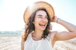 Lachende vrouw staat met haar rug richting de zon Lachende vrouw staat met haar rug richting de zon