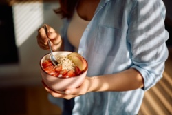 Vrouw houdt kom met havermout vast Vrouw houdt kom met havermout vast