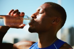 Man drinkt uit een fles water