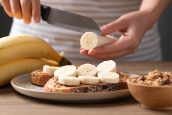 Plakjes banaan op een broodje pindakaas Plakjes banaan op een broodje pindakaas